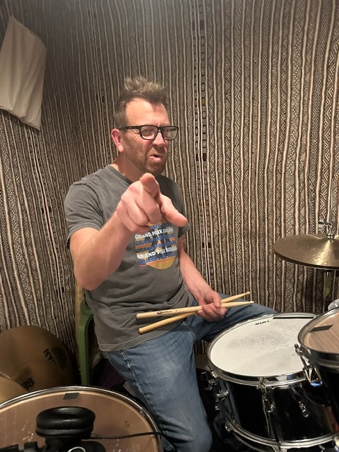 Drummer pointing at camera in rehearsal